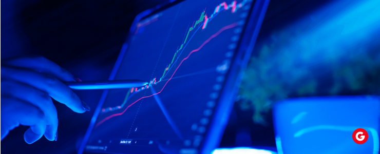 A person focused on a laptop displaying a stock chart, analyzing financial data for investment decisions.